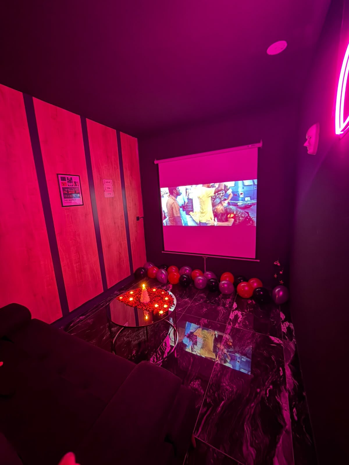 Doğum günü için hazırlanmış oda: perdede film, zeminde balonlar ve oturma grubu
